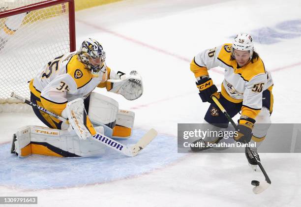 Erik Haula of the Nashville Predators clears the puck in front of Pekka Rinne against the Chicago Blackhawks at the United Center on March 28, 2021...