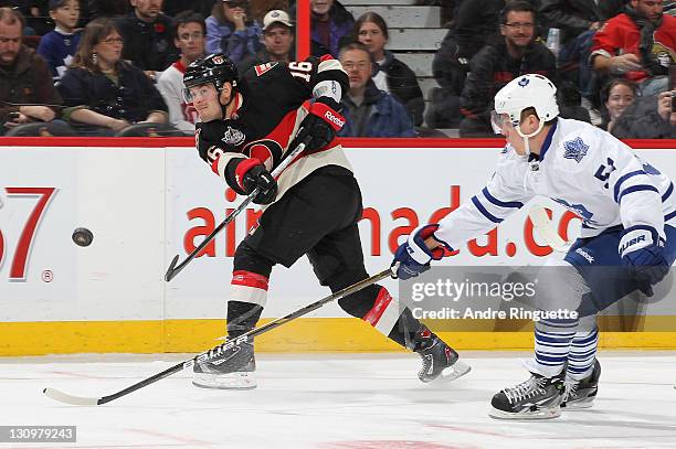 Bobby Butler of the Ottawa Senators shoots the puck over the outstretched stick of Jake Gardiner of the Toronto Maple Leafs at Scotiabank Place on...