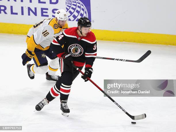 Carl Soderberg of the Chicago Blackhawks advances the puck past Colton Sissons of the Nashville Predators at the United Center on March 28, 2021 in...