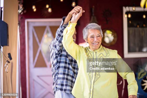 pareja mexicana mayor bailando en casa - bailando salsa fotografías e imágenes de stock