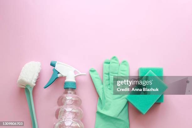 blue cleaning supplies: bottle with chemicals, gloves, sponges and brushes over pink background. flat lay with copy space. - prodotto per le pulizie foto e immagini stock