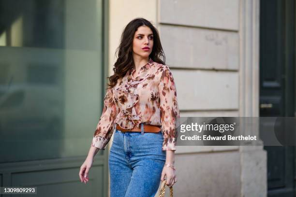 Sara Carnicella @lafillerebelle wears earrings from APM Monaco, a pink and purple floral print flowing shirt from Liu Jo, a brown leather belt from...