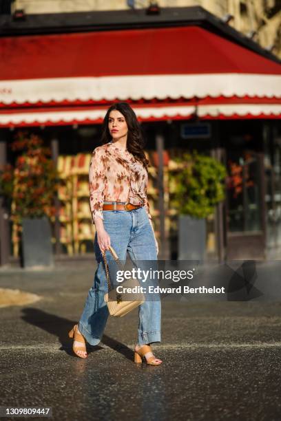 Sara Carnicella @lafillerebelle wears earrings from APM Monaco, a pink and purple floral print flowing shirt from Liu Jo, a brown leather belt from...