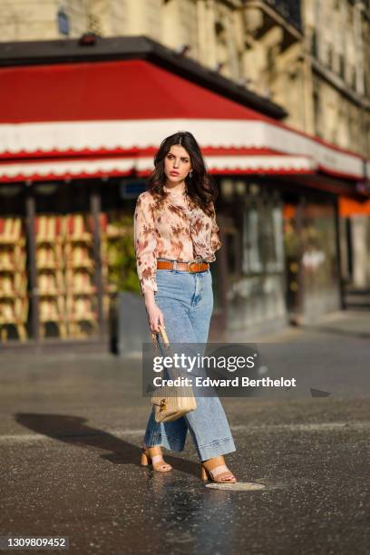 Sara Carnicella @lafillerebelle wears earrings from APM Monaco, a pink and purple floral print flowing shirt from Liu Jo, a brown leather belt from...