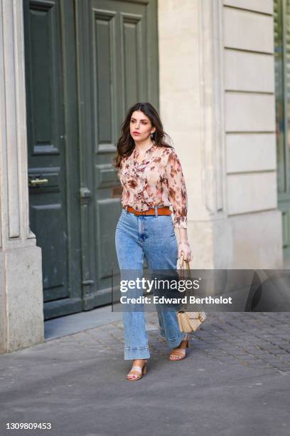 Sara Carnicella @lafillerebelle wears earrings from APM Monaco, a pink and purple floral print flowing shirt from Liu Jo, a brown leather belt from...