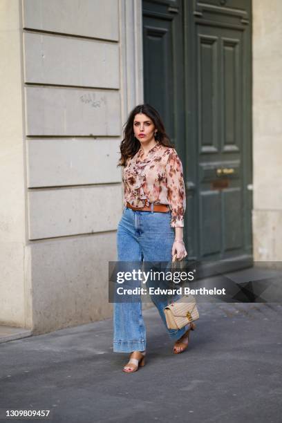 Sara Carnicella @lafillerebelle wears earrings from APM Monaco, a pink and purple floral print flowing shirt from Liu Jo, a brown leather belt from...