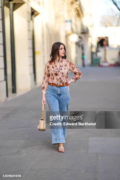 Sara Carnicella @lafillerebelle wears earrings from APM Monaco, a pink and purple floral print flowing shirt from Liu Jo, a brown leather belt from...