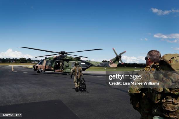 Member of the 5th Aviation Regiment, Townsville leads personnel toward a MRH-90 Taipan in preparation for departure from Taree Airport as part of...