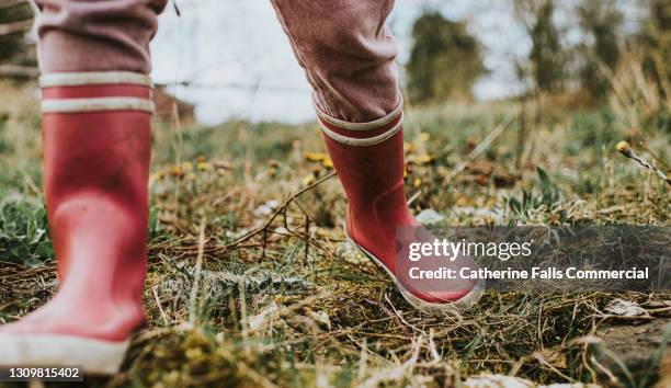 child wearing pink wellies takes a big step towards the camera - stamping feet stock pictures, royalty-free photos & images