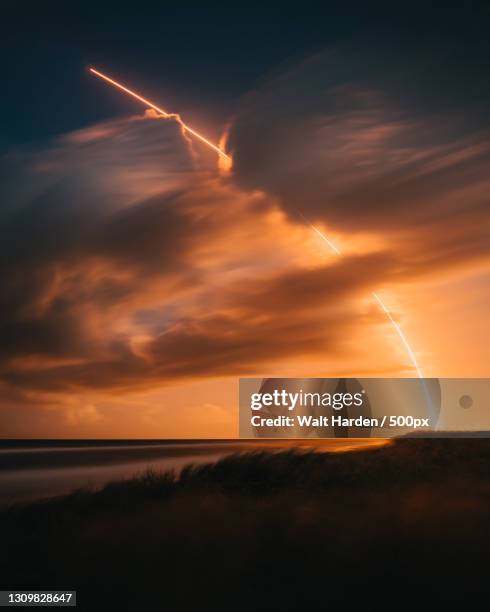 scenic view of vapor trails in sky during sunset,canaveral national seashore,florida,united states,usa - cohete despegue fotografías e imágenes de stock