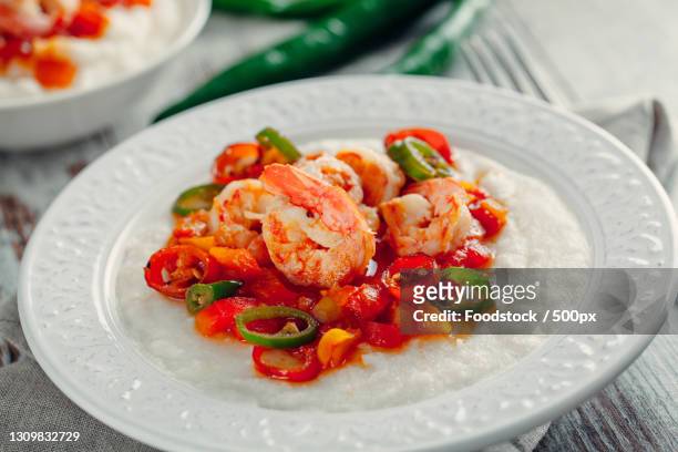 close-up of seafood in plate on table - shrimp and grits stock-fotos und bilder