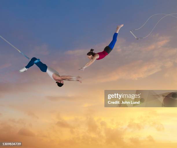 flying trapeze teamwork - trapez stock-fotos und bilder