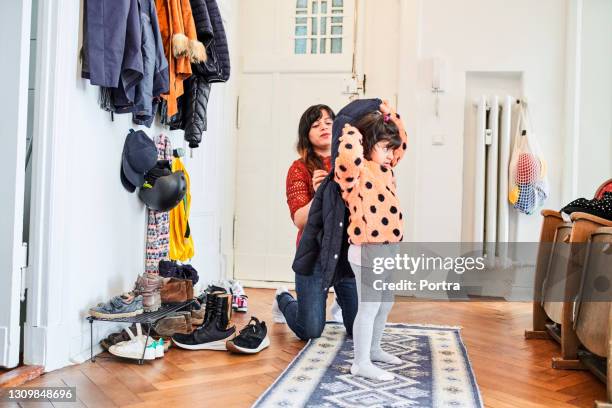 mädchen immer von mutter in mudroom gekleidet - jacke stock-fotos und bilder