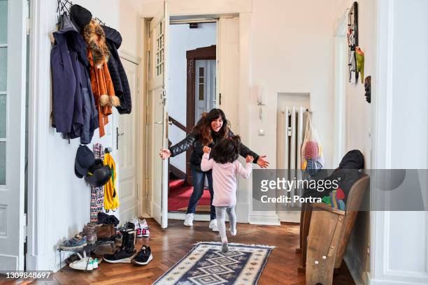 girl running towards happy mother at doorway - arriving home stock pictures, royalty-free photos & images