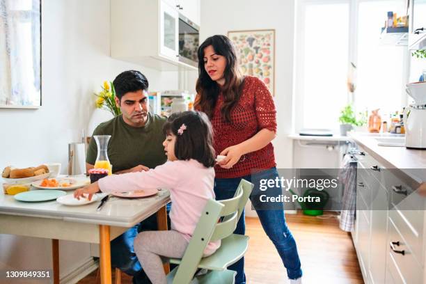 family eating breakfast at dining table in kitchen - indian family dinner table stock pictures, royalty-free photos & images