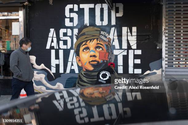 Person walks past a 'Stop Asian Hate' mural by Dragon76 in Chinatown on March 29, 2021 in New York City. The installation was commissioned by East...