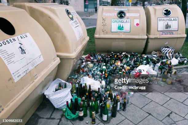 botellas vacías junto a contenedores de reciclaje en la calle - beer bottle fotografías e imágenes de stock