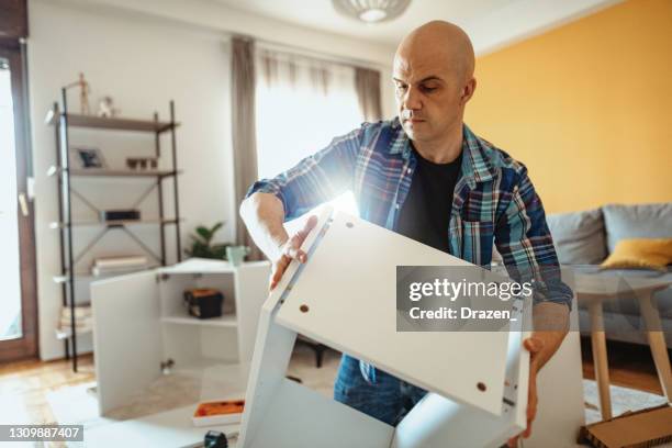 repairman working at home and assembling furniture during covid-19 lockdown - lockdown drill stock pictures, royalty-free photos & images