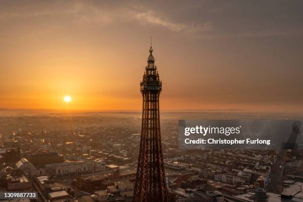 In an aerial view from a drone, the sun rises behind Blackpool Tower on March 30, 2021 in Blackpool, United Kingdom. Parts of the UK are set to see...