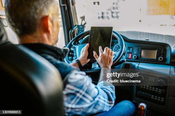 conductor de camión usando una aplicación móvil - trucker fotografías e imágenes de stock