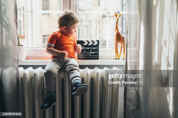 baby boy playing by the window - child with giraffe toy stock pictures, royalty-free photos & images