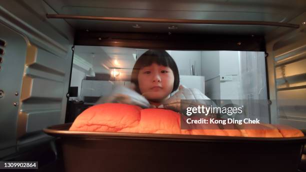 asian chinese girl waiting her baking bread food in the oven in the kitchen - inside of oven stock pictures, royalty-free photos & images