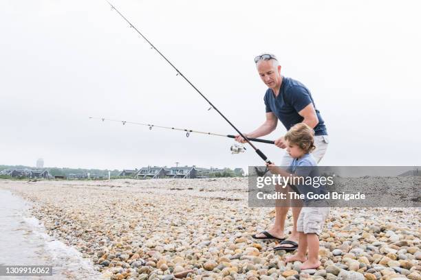 father and son fishing at the beach - long island beach stock pictures, royalty-free photos & images