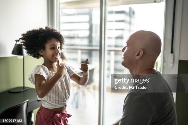 father and daughter at home speaking in sign language - sign language stock pictures, royalty-free photos & images