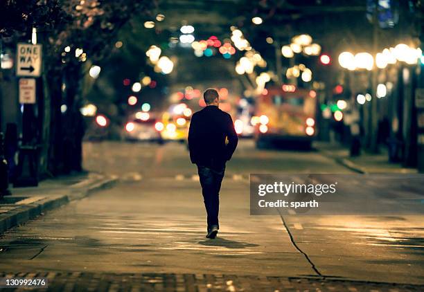 silhouette walking in downtown seattle - lonely man stockfoto's en -beelden