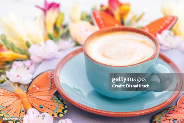 blue cup with creamy coffee in boho style with freesias, cherry blossoms and butterflies - freesia flowers stock pictures, royalty-free photos & images