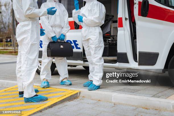 emergency doctors in front of ambulance car wearing  protection workwear - coveralls stock pictures, royalty-free photos & images