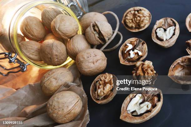 raw unpeeled and cracked walnuts on stone plate - brain in a jar stock pictures, royalty-free photos & images