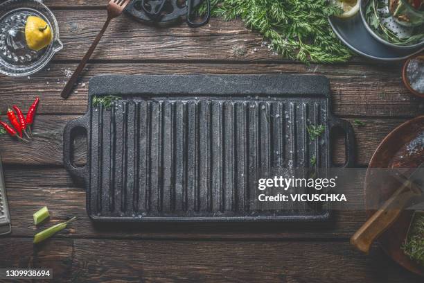 food background with empty cast iron grill grate on wooden background with utensils and ingredients. - grille stock pictures, royalty-free photos & images