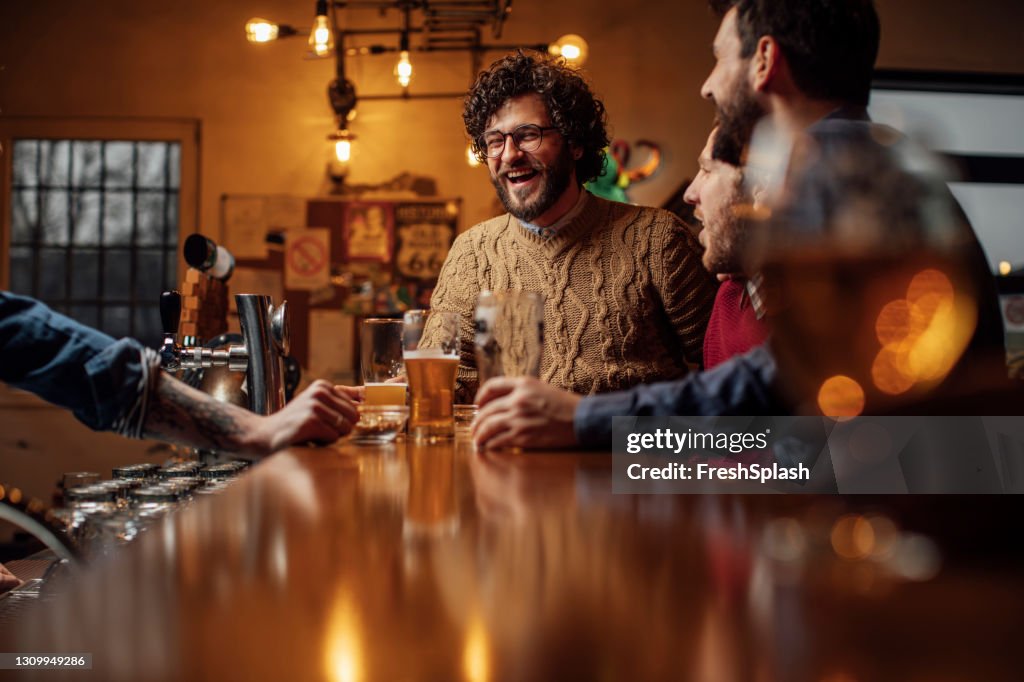 Group of Happy Men Drinking Beer at the Bar