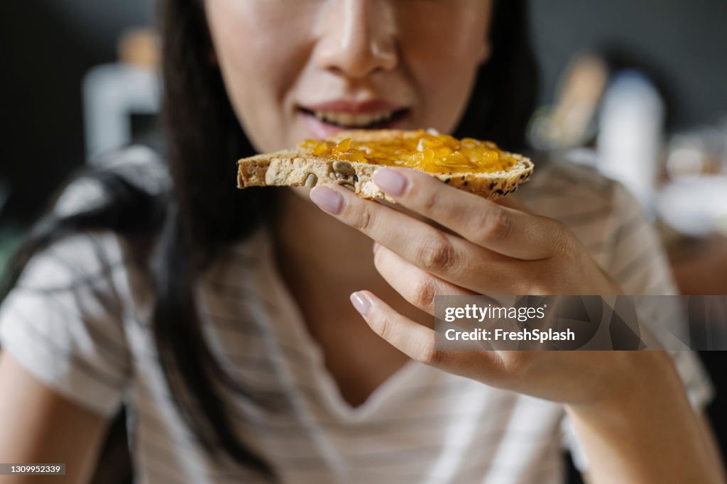 La comida más importante del día: una joven irreconocible que desayuna en casa