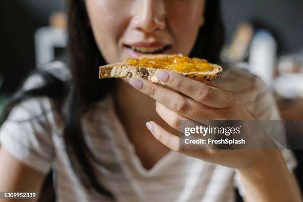 la comida más importante del día: una joven irreconocible que desayuna en casa - carbohidrato fotografías e imágenes de stock