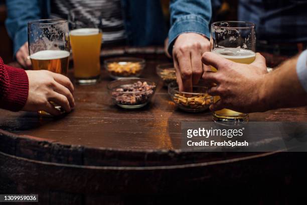 cerveja e lanches: grupo de homens irreconhecíveis no bar juntos, um close up - peanuts - fotografias e filmes do acervo