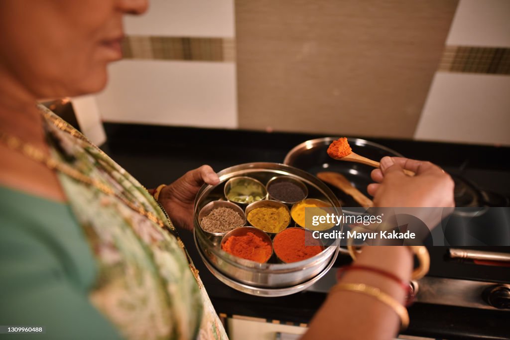 Woman using spices while cooking food
