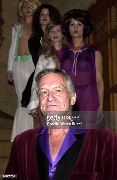 Playboy founder Hugh Hefner poses with playmates, left to right, Kalin Olson, Carrie Stevens, Deanna Brooks and Karen McDougal dressed as pinup girls...