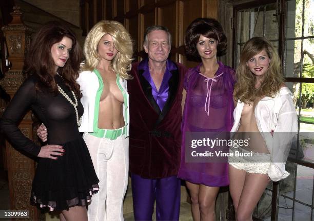 Playboy founder Hugh Hefner, center, poses with playmates, left to right, Carrie Stevens, Kalin Olson, Karen McDougal and Deanna Brooks dressed as...
