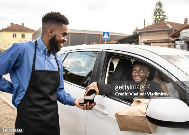 一位客戶在收集路邊送外賣食品時用非接觸式技術付款 - curbside pickup 個照片及圖片檔