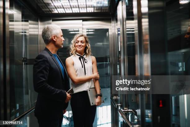 gens d’affaires dans le travail de finition de bâtiment d’entreprise - elevator stock photos et images de collection