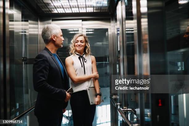 business people in the corporate building finishing work - elevator stock pictures, royalty-free photos & images