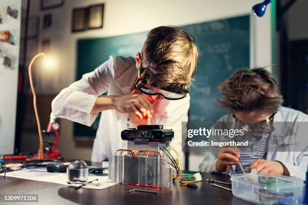 two little inventors are building a mysterious device - mad scientist stock pictures, royalty-free photos & images