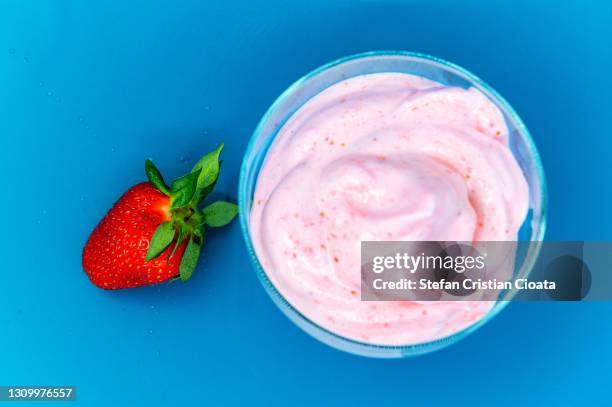 strawberry smoothie cup on blue background, close-up, macro - jogurt textur stock-fotos und bilder