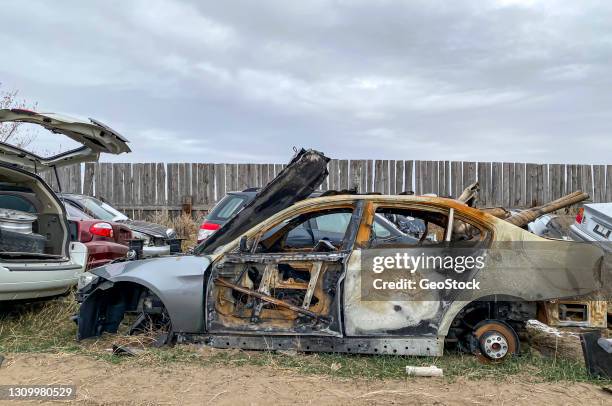 burned-out car in a salvage yard - burned corpse stock pictures, royalty-free photos & images