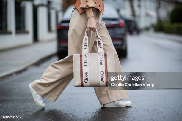 Alexandra Lapp is seen wearing LOEWE cut-out Obi belt in tan, CHLOÈ knitted jumper in beige, LOEWE pleated wide trousers in beige, CHLOÈ Woody...