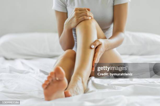 woman touching her skin with hand - women touching herself in bed stock pictures, royalty-free photos & images