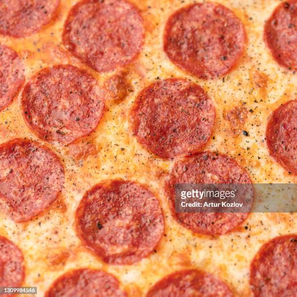 pepperoni pizza with salami sausage and melted cheese, super close up shot. food background or texture. soft focus - pepperoni pizza stock-fotos und bilder
