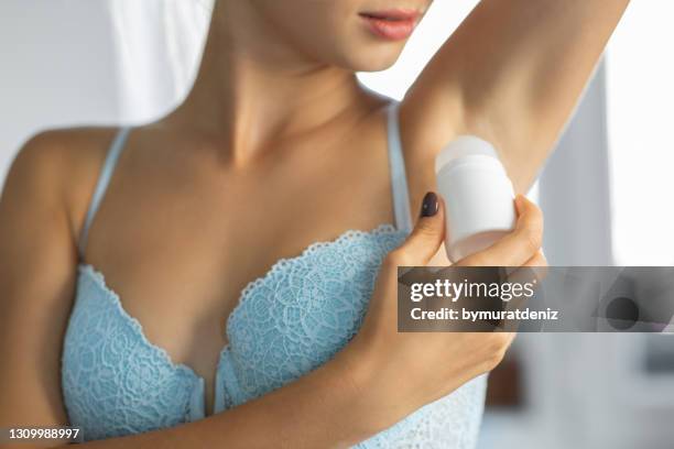 young woman using deodorant - air freshener stock pictures, royalty-free photos & images